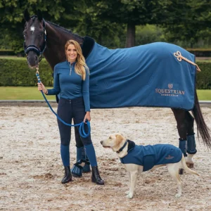 A woman standing next to a horse and dog.