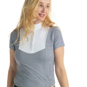 A woman in black and white shirt standing next to wall.